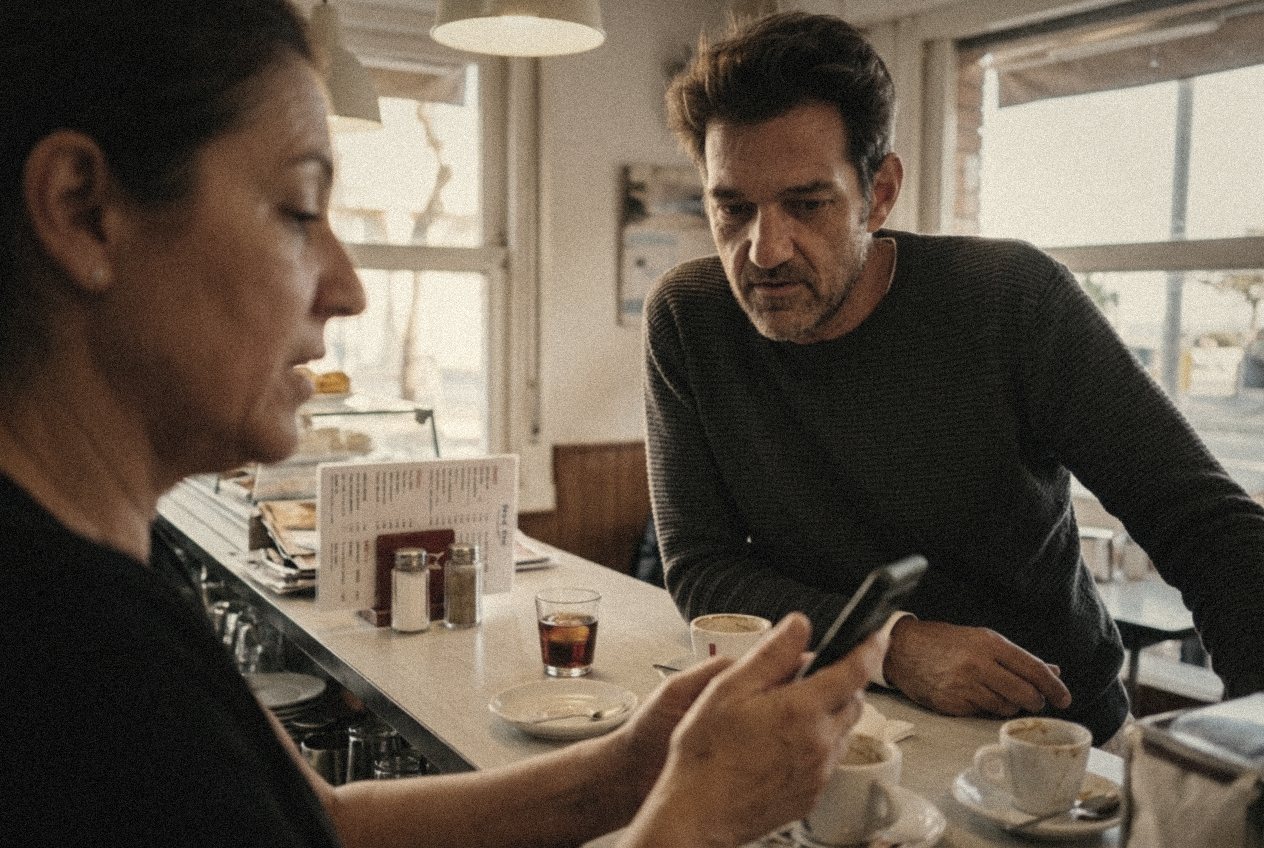 En Dani revisant amb la propietària d'un bar una eina al mòbil